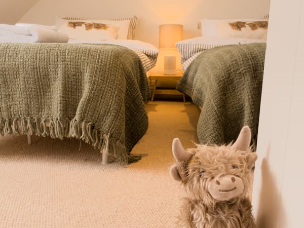 Twin beds with a Highland cow toy